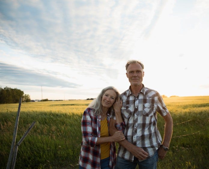 older couple smiling in a grass field