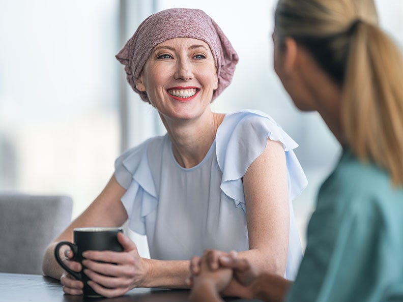 woman with head scarf smiling and talking with someone