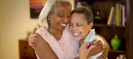 two smiling women embrace