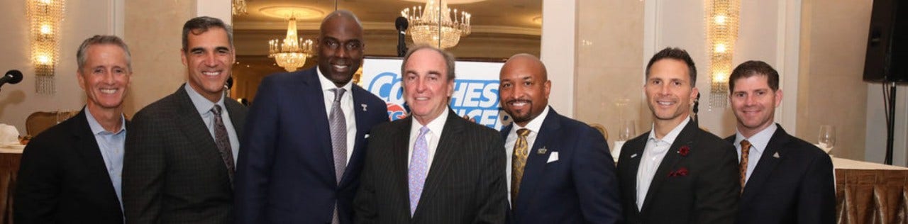 basketball coaches in suits standing together at a gala function