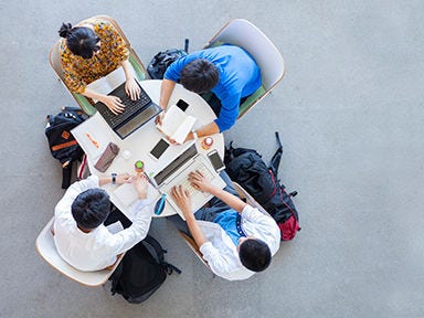 A top down image of a group of individuals learning and collaborating at a round table