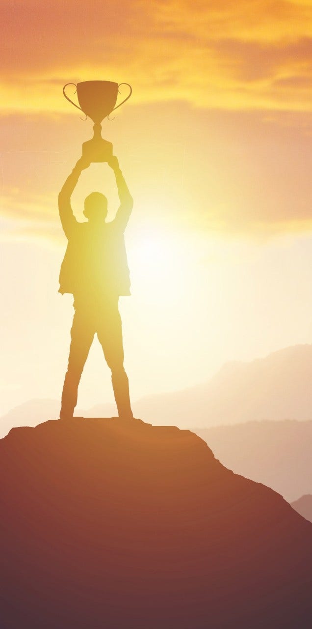 Silhouette of a man holding a trophy at sunset. Success concept