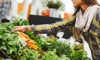 A woman picking fresh vegetables at the market