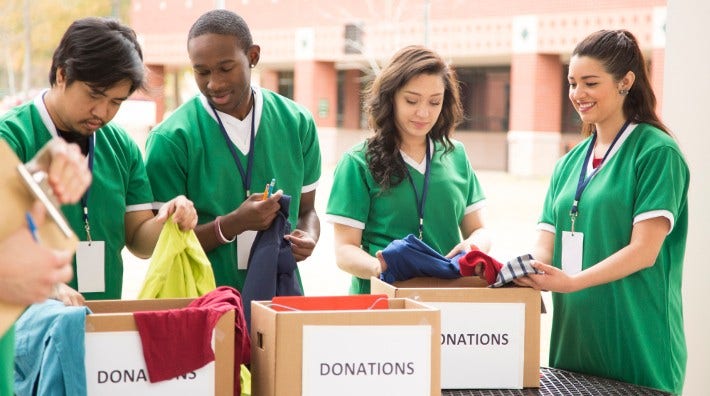 diverse group of teens volunteer with donations boxes