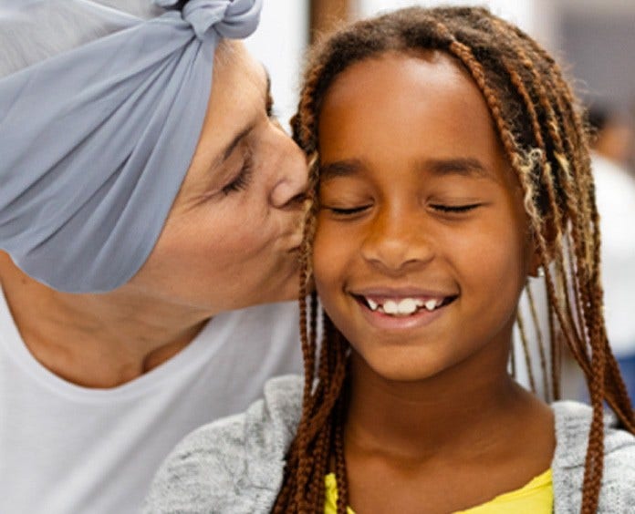 elderly woman kissing child on cheek