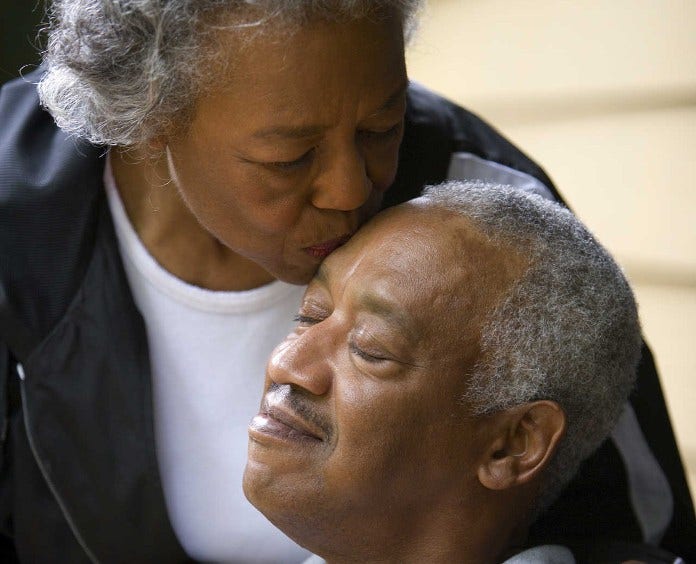 woman kisses man on forehead