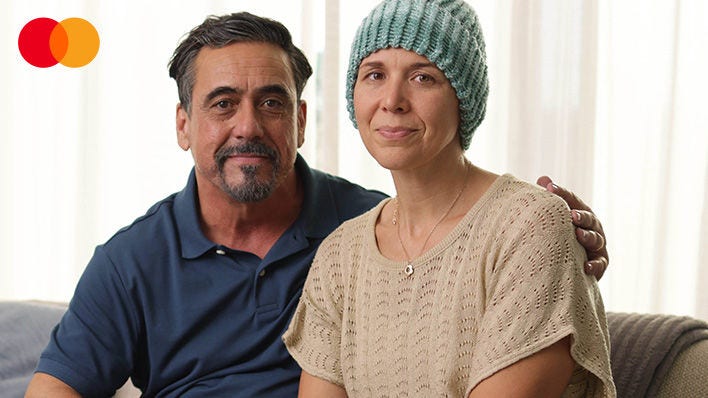 man with arm around his wife wearing a green beanie hat