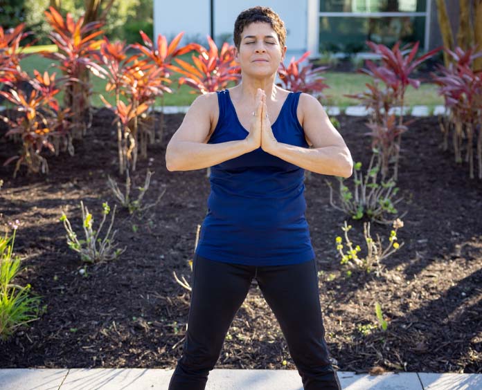 A woman meditating doing yoga on sidewalk outdoors acs empower hope lodge image