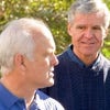 group of middle aged men talking outside