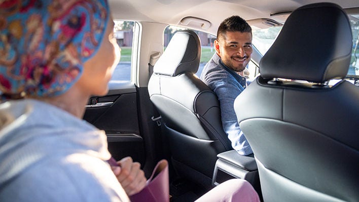 Paciente con cáncer recibiendo transporte a su tratamiento con un voluntario.