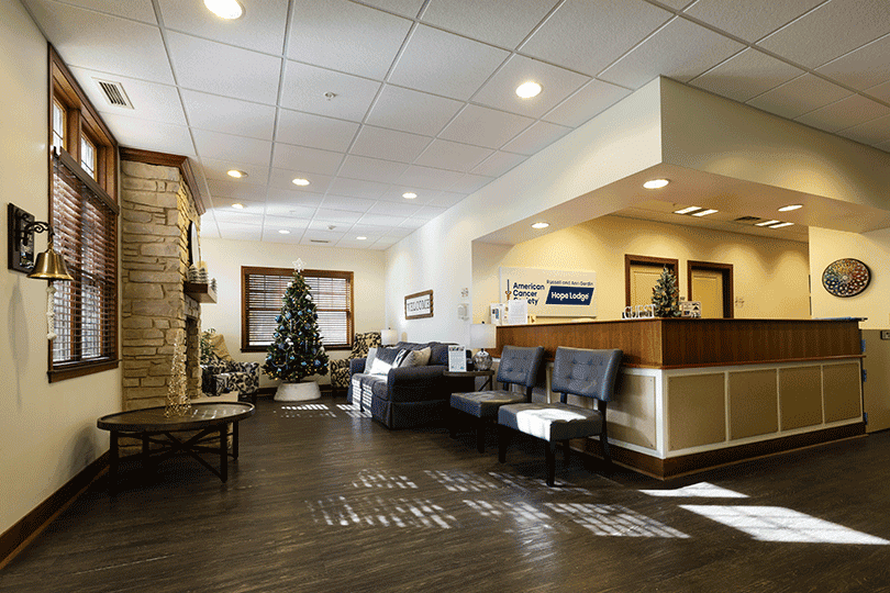 Waiting room with reception desk, chairs, fireplace, and Christmas tree.