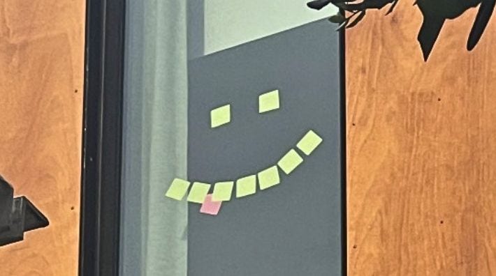 Yellow sticky notes in the shape of a smiling face in the Hope Lodge window