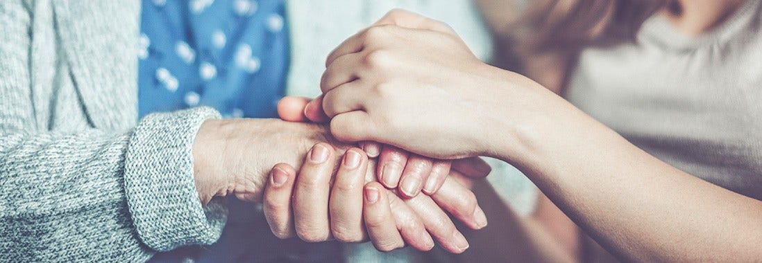 Close up of two women holding both hands