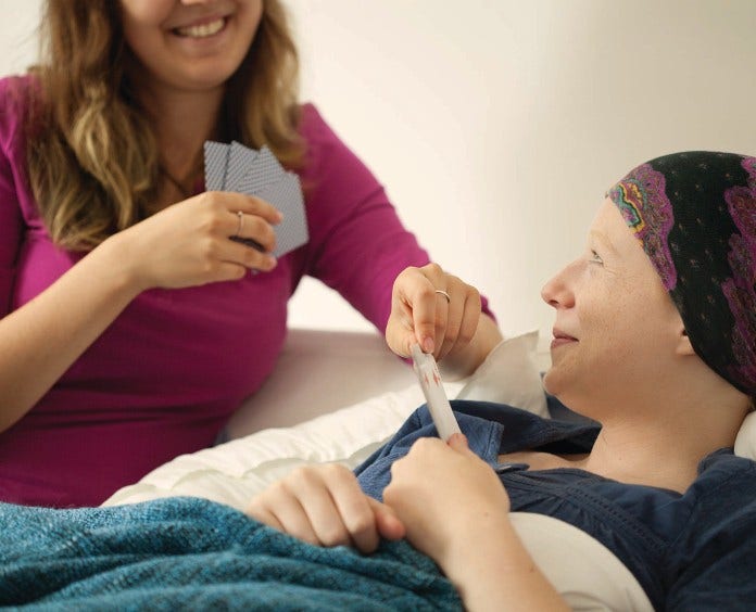 caregiver and cancer patient playing cards