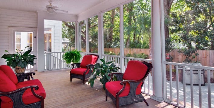 Exterior porch sitting area with red and black chairs