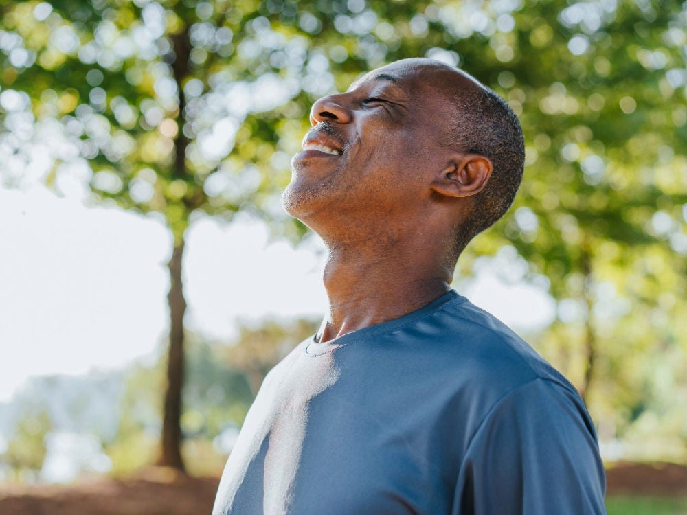 picture of a man inhaling fresh air outdoors