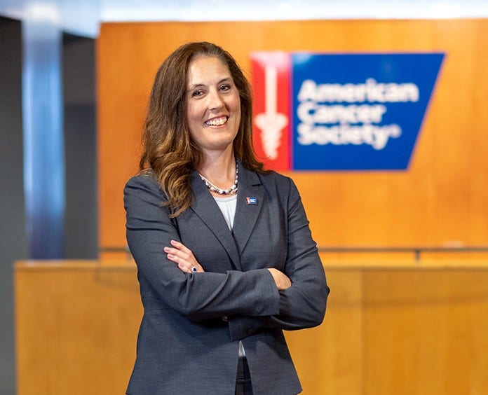 Dr. Karen Knudsen, CEO of the American Cancer Society and ACS-CAN in front of ACS logo