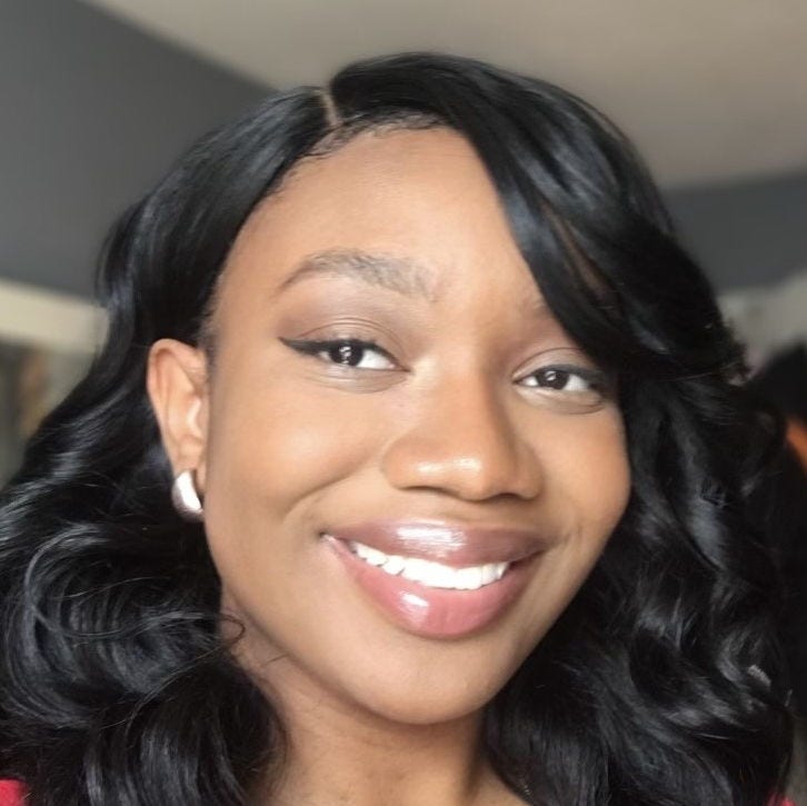 Headshot of researcher Anatu Saka, MPH. Red blouse, shoulder length black hair, studded earrings. 