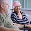 woman wearing pink hat smiling while sitting next to man