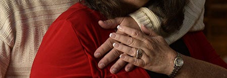 Imagen en primer plano de dos personas abrazándose las manos.