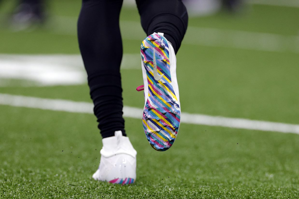 man in football cleats running on field