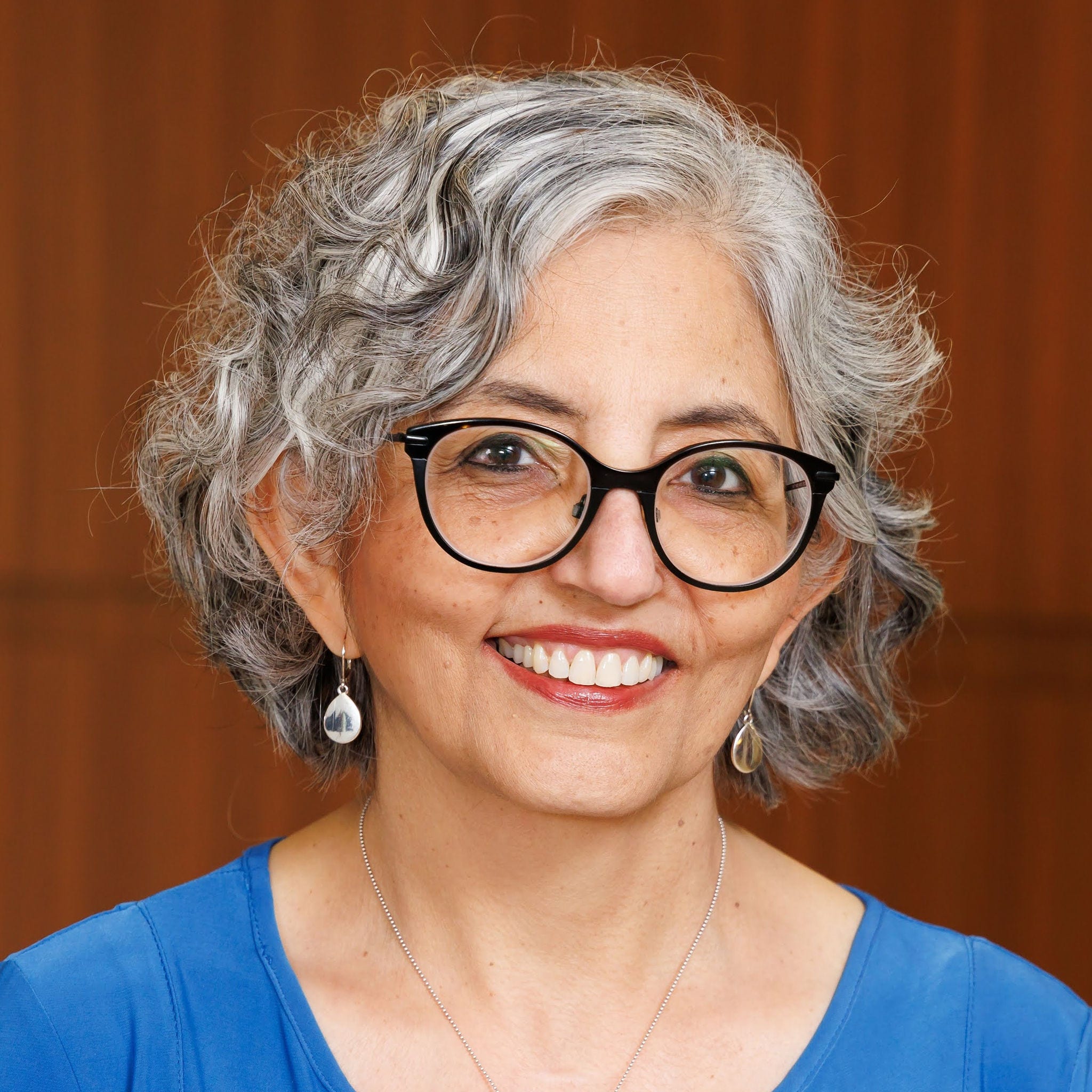Headshot of research professor Smita Bhatia, MD, in black rimmed eyeglasses and a blue blouse.