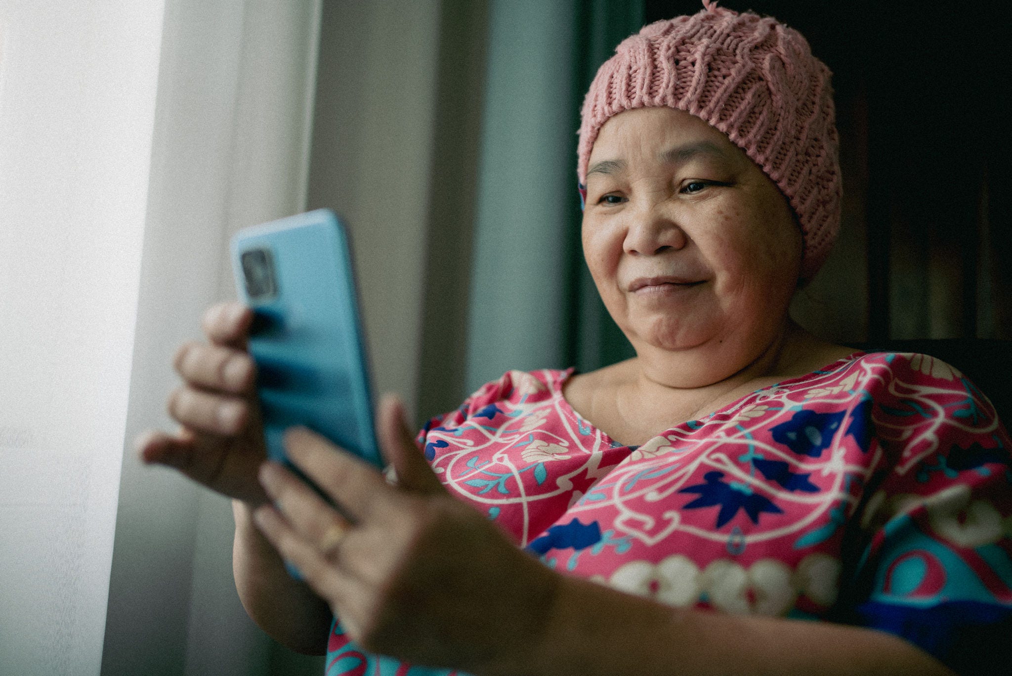 A woman with Cancer, uses a Smart Phone to access american cancer society 24/7 cancer hotline
