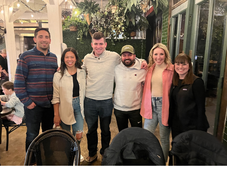 Group of friends smiling together indoors at a restaurant.