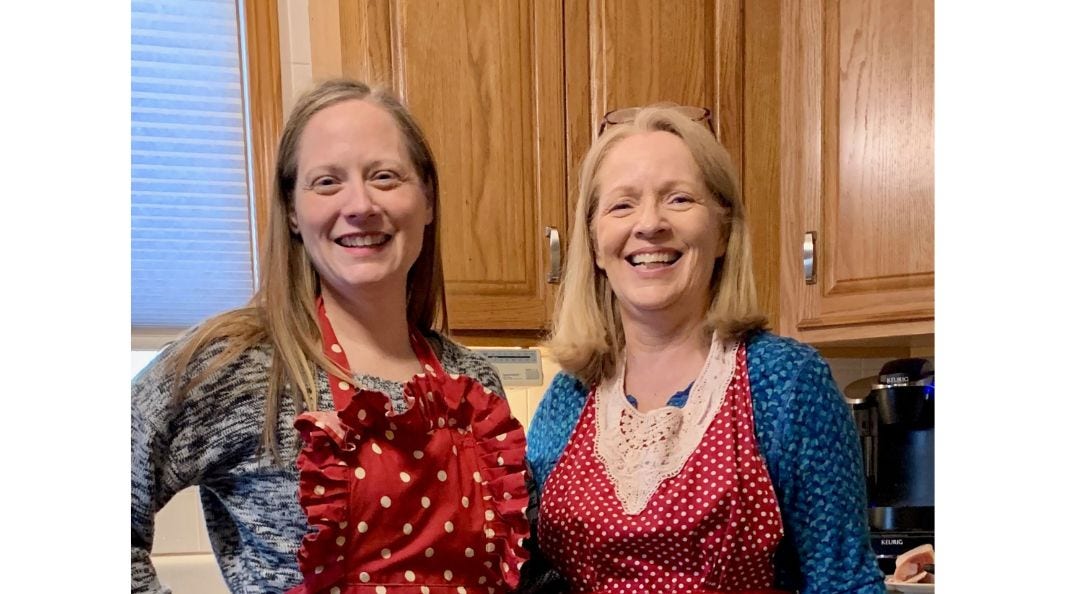 Patty Schone and daughter in aprons smiling