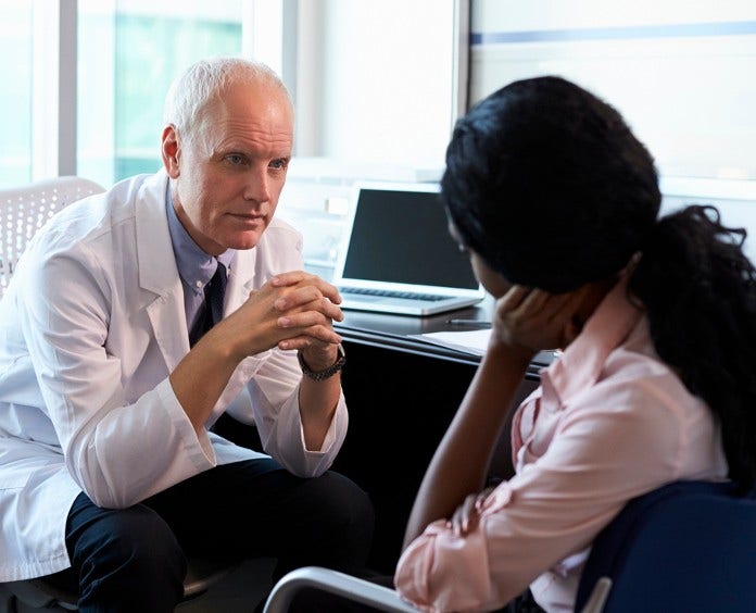 male doctor counsels a female patient in his office