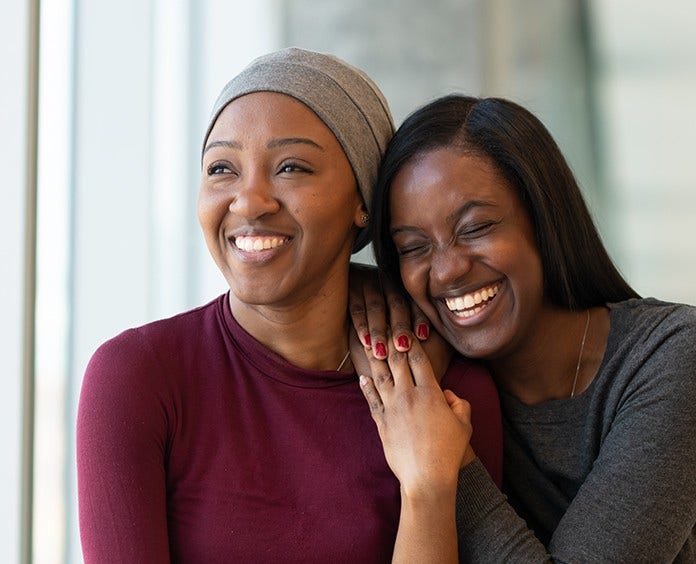 two African American women embracing in a friendly hug