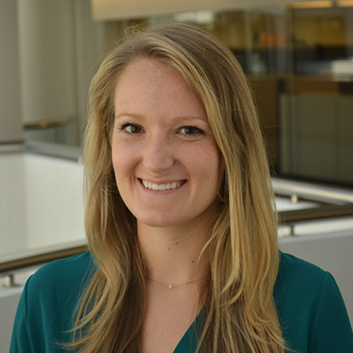 headshot of woman with long blond hair in front of office windows