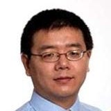 Asian man with glasses wearing blue shirt and white and gray tie