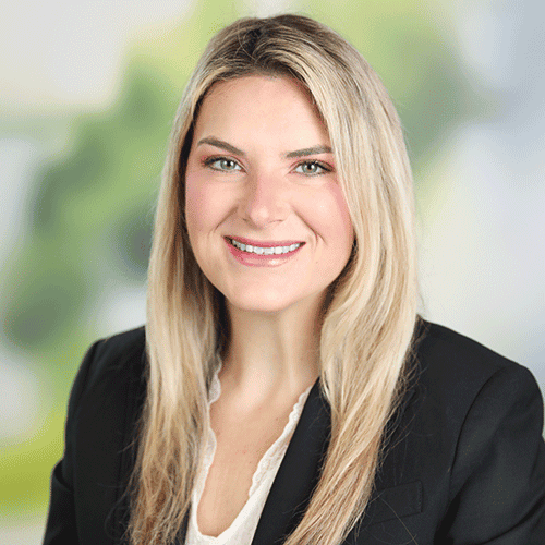 Professional woman with blonde hair wearing black blazer smiling.