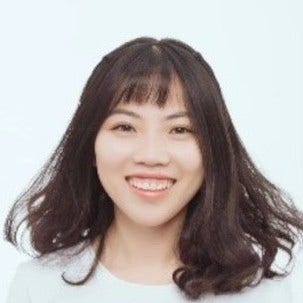 Asian woman with fluffy brown hair, white scoop neck top