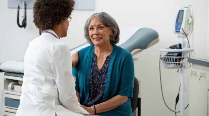 doctor with hand on happy patient's shoulder