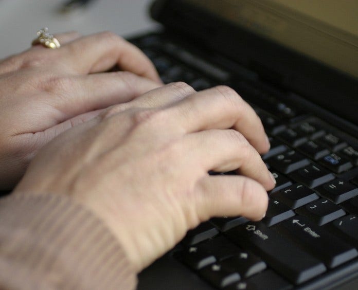 close up of hands on laptop keyboard