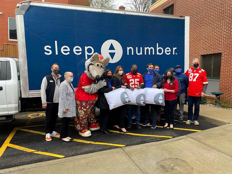 group of people standing in front of Sleep Number box truck 