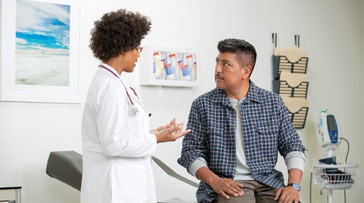 female doctor advising a middle aged male patient in exam room