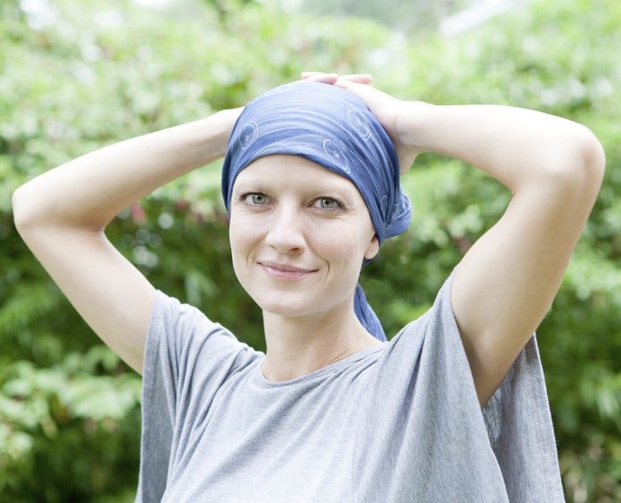 smiling female cancer patient in head scarf