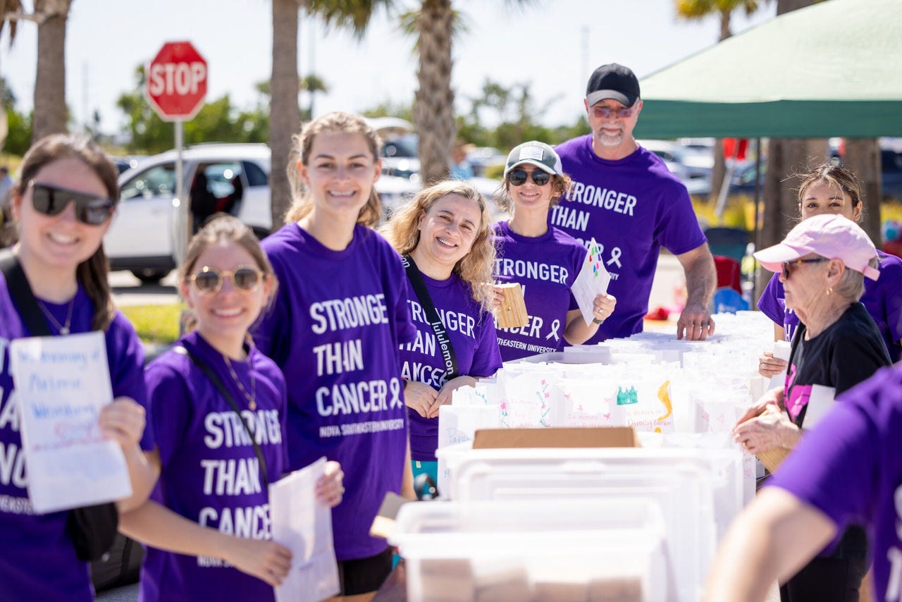 Volunteers in purple shirts supporting cancer