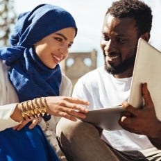 couple working on a laptop outside