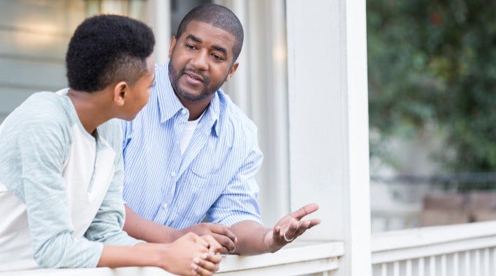 father and son having discussion on porch