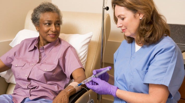 nurse gives chemo patient injection