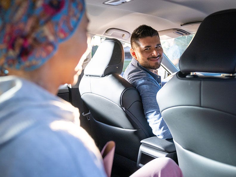 driver looking at passenger in the backseat of car