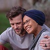 white male hugging woman wearing head scarf