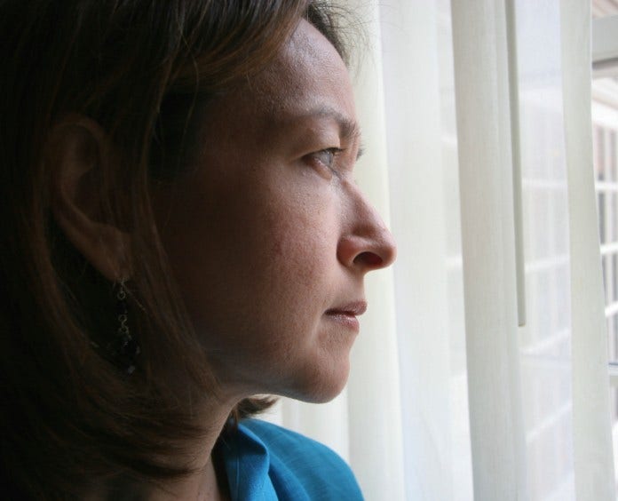 sad woman looks out of window