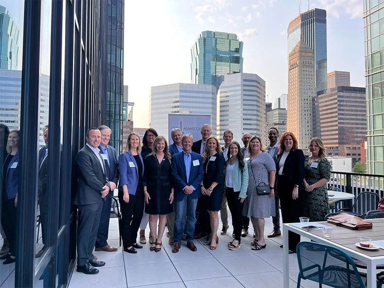 group of white professionals standing on high-rise building terrace