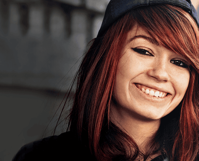 young woman with red hair wearing baseball cap
