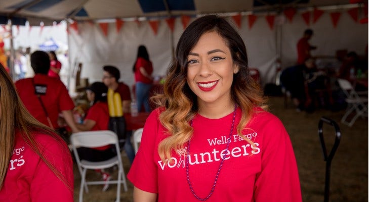 caucasian female at an event waring red volunteer shirt